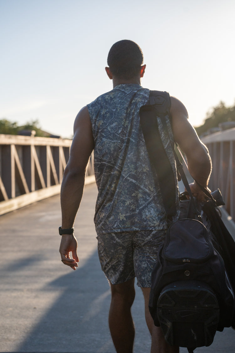 Golfer walking a sunlit bridge with a golf bag